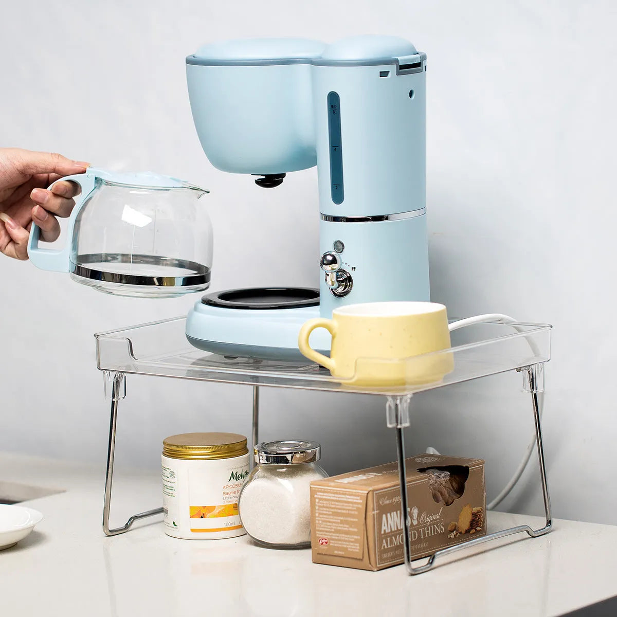 A transparent or white plastic kitchen supplies rack for organising utensils on a desktop or in a cupboard.