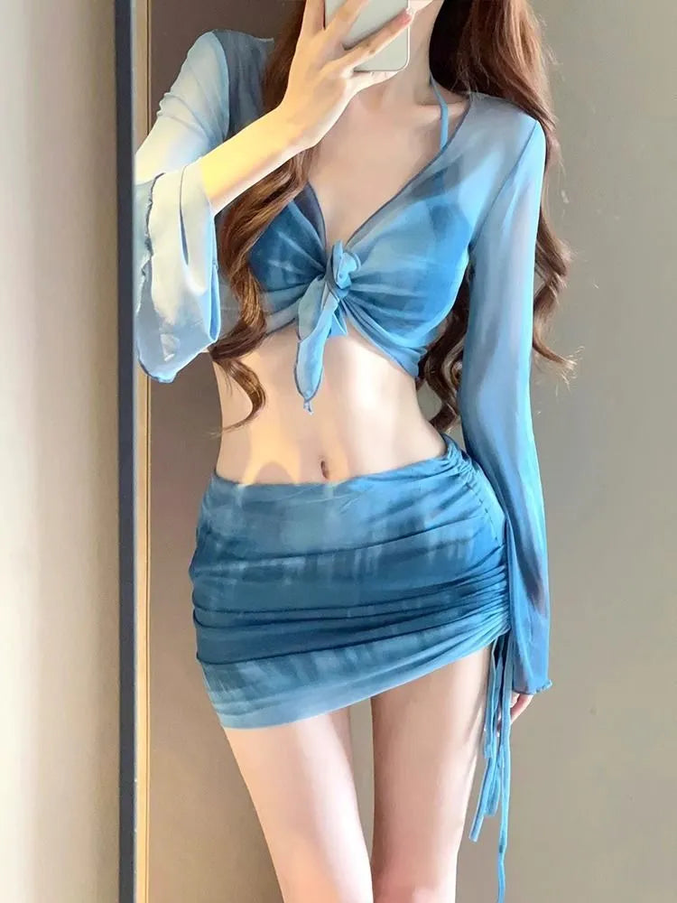 Blue high-waisted women's bikini set with matching shirt and skirt laid flat.