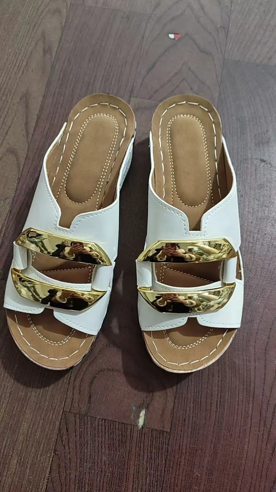 Men's white Roman-style platform sandals with a flat rubber sole and decorative metal details on the strap.