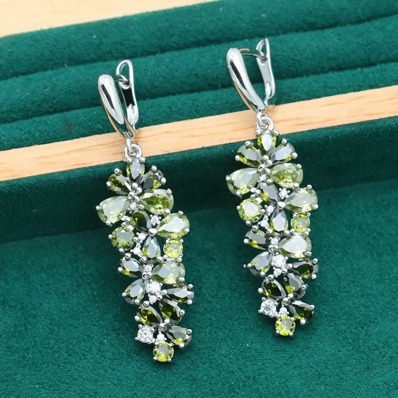 Retro style jewellery set showing necklace with floral pendant, bracelet, earrings, and ring in olive and purple colours.