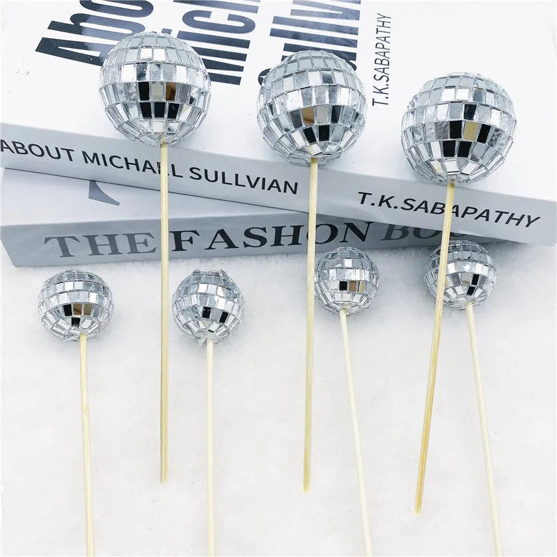 Glass disco ball cake decoration with wooden stick, shown in various sizes from 2.5cm to 5cm.