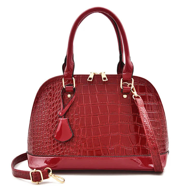 Shiny PU leather crossbody bag in shell shape design showing black, red and brown colour options