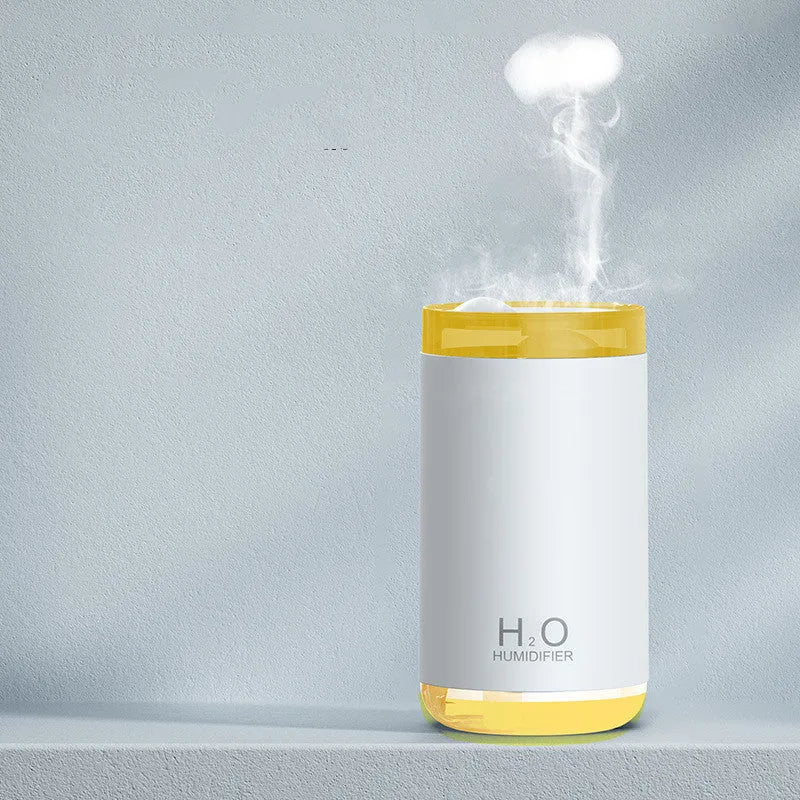White jellyfish-shaped USB humidifier with warm night light on a wooden table.