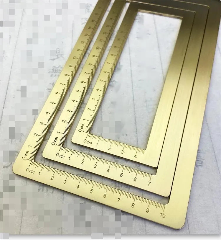 Solid brass square calligraphy paper weight with engraved design on a wooden desk.