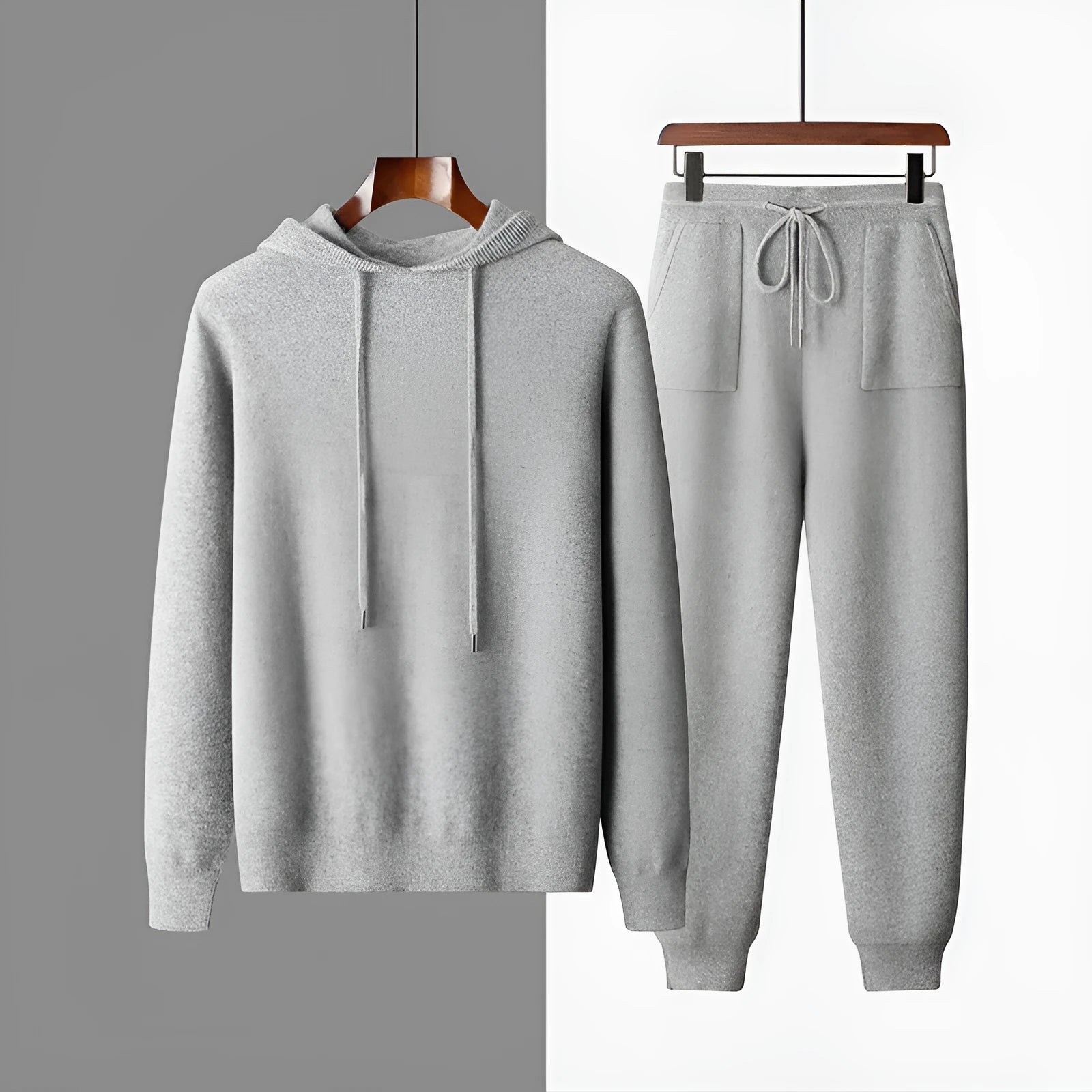 Men's light grey hooded cashmere sweatshirt and matching long pants laid flat as a complete casual winter set.