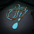 Long turquoise blue water drop pendant necklace with mixed gem inlay on a ball bead chain for women.