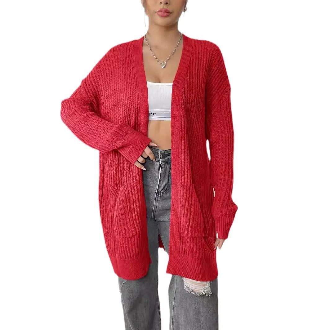A women's loose dark green cardigan sweater with two pockets and long sleeves.