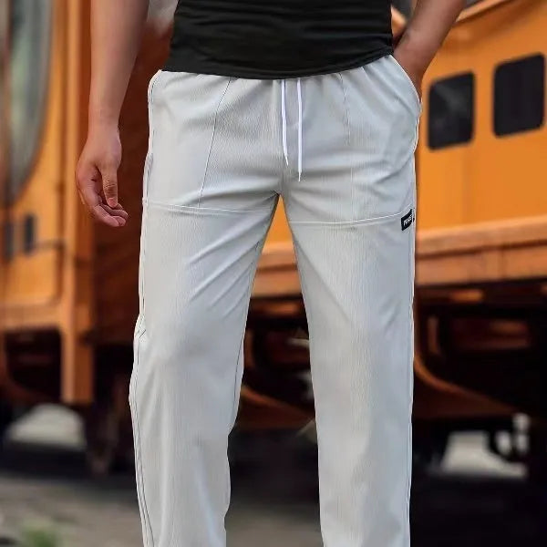 Men's polyester trousers in light grey, shown flat, with a size label indicating S-XXXL range.