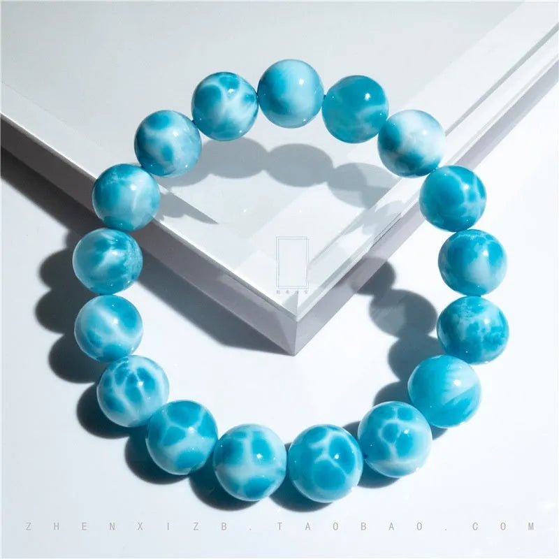 Blue Bodhi bracelet with natural sea-pattern crystal bead and pearl details in Maillard style.