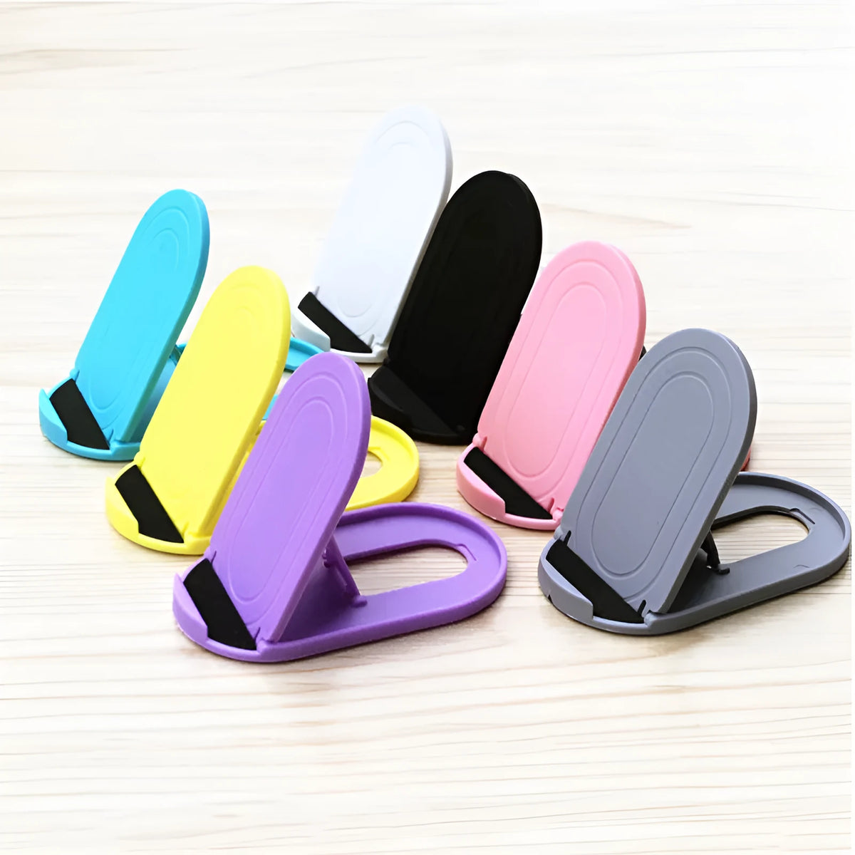A plastic lazy bracket mobile phone stand holding a smartphone, shown in multiple colour options.