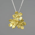 Hand-designed sterling silver Myosotis flower pendant in pastoral style, showing gold and silver colour options.