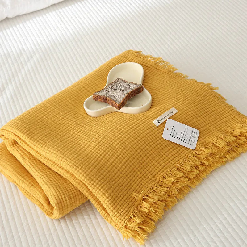 Cotton four-layer gauze blanket with tassel trim in a choice of ten colours and two sizes.