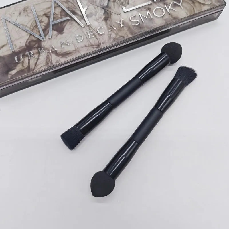Double-headed makeup brush with black sponge end and pointed brush end on wooden handle