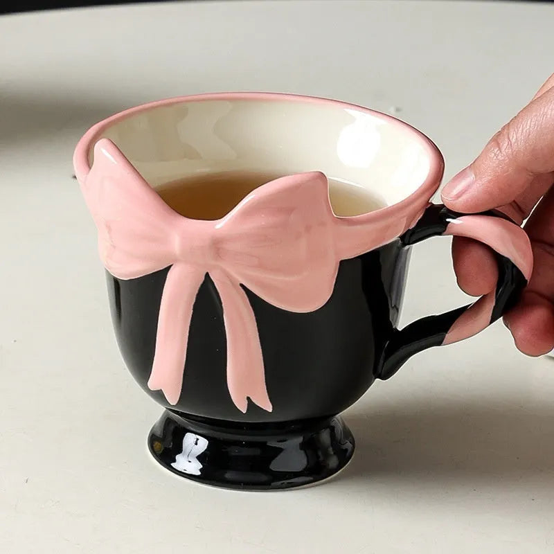 Ceramic mug with heart and bow design in white or black pink colours