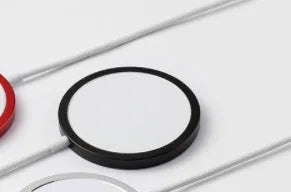 Silver metal magnetic wireless charger for Apple iPhone on a table