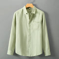 Linen long sleeve loose fit shirt in light green colour, shown on a hanger.