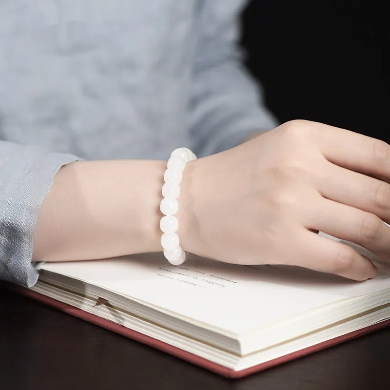 White Hetian jade barrel bead bracelet on a wrist, showing unisex casual style