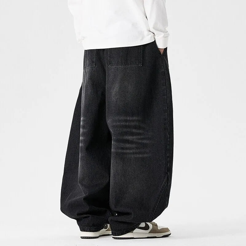 Man wearing black plus-size baggy denim jeans with a straight leg and low waist.