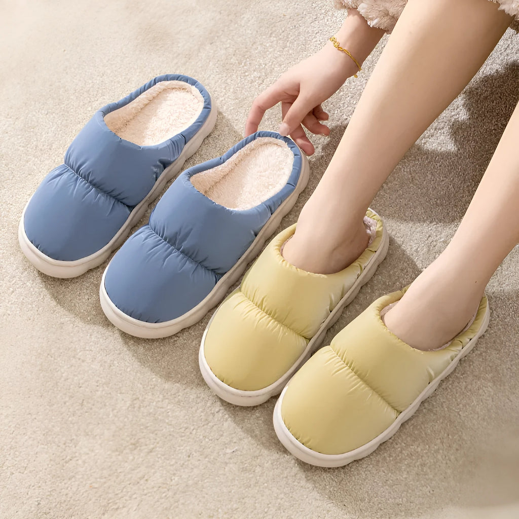 A pair of thick-soled plush slippers with artificial leather uppers and non-slip rubber soles in a choice of five colours.