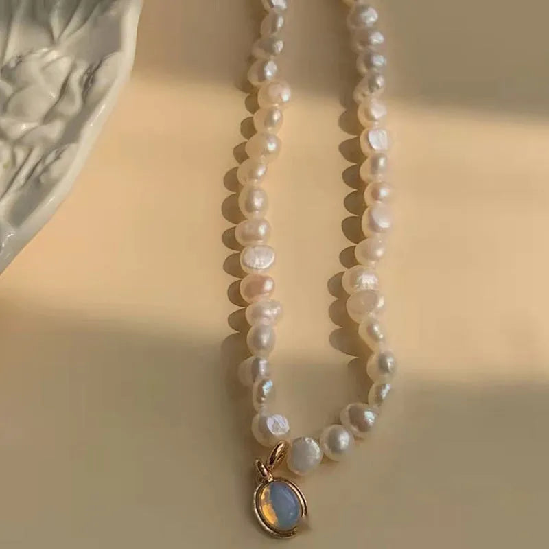 Vintage pearl necklace with geometric pendant on adjustable chain.