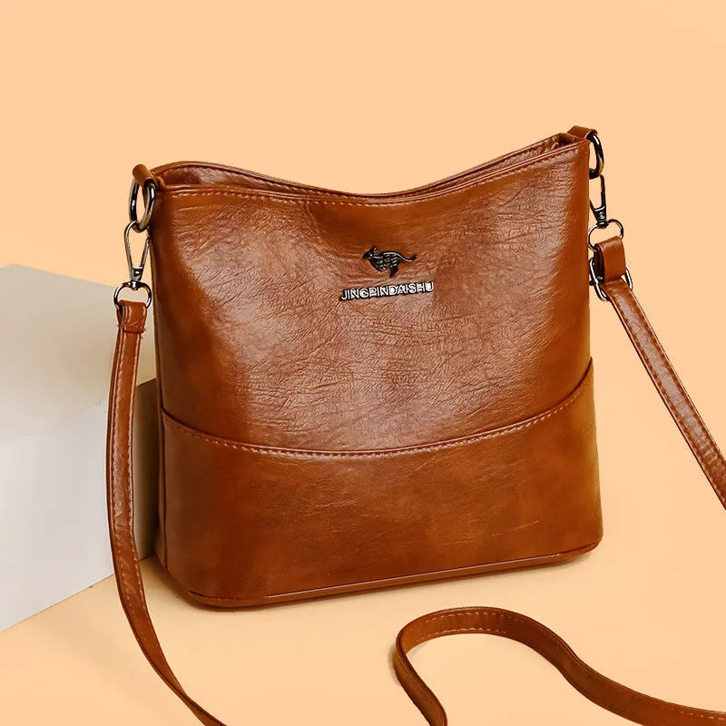 Women's soft leather bucket shoulder bag in a solid colour with visible sewing lines.