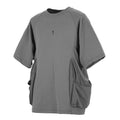 Man wearing a loose grey cotton T-shirt with large side pockets, round neck, and short sleeves.