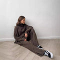 Women's dark grey acrylic jumper suit with side slits on the top and matching trousers.