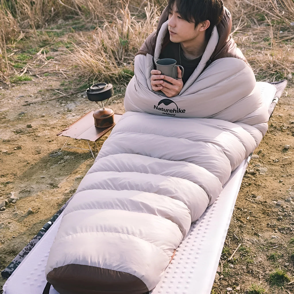 Mummy style goose down sleeping bag for adults shown with its storage bag