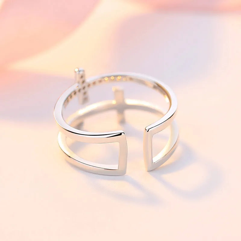 Women's geometric adjustable copper ring with sterling silver and zircon inlay on a hand.