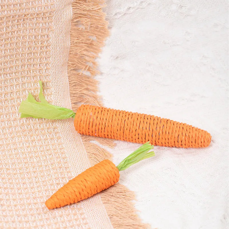 Bundle of cat toys including carrot-shaped chews, crinkly paper rings, and audible ringing stones in multiple sizes