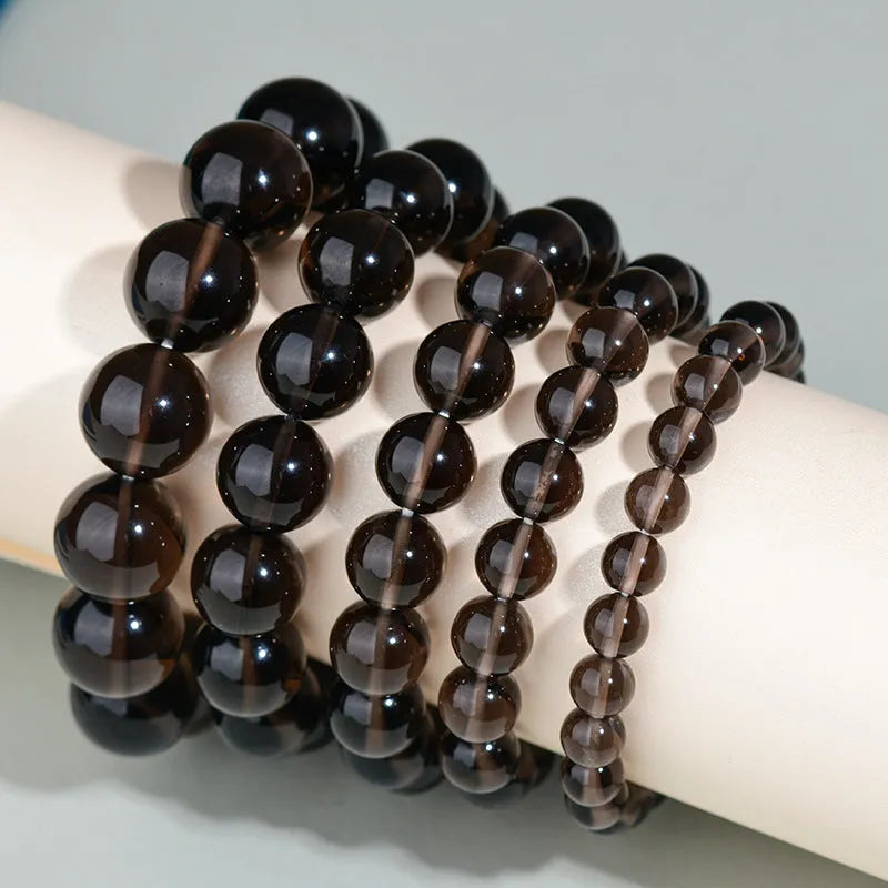 Hand-woven round obsidian crystal bracelet in ethnic style on a wrist, showing colour and bead size options.