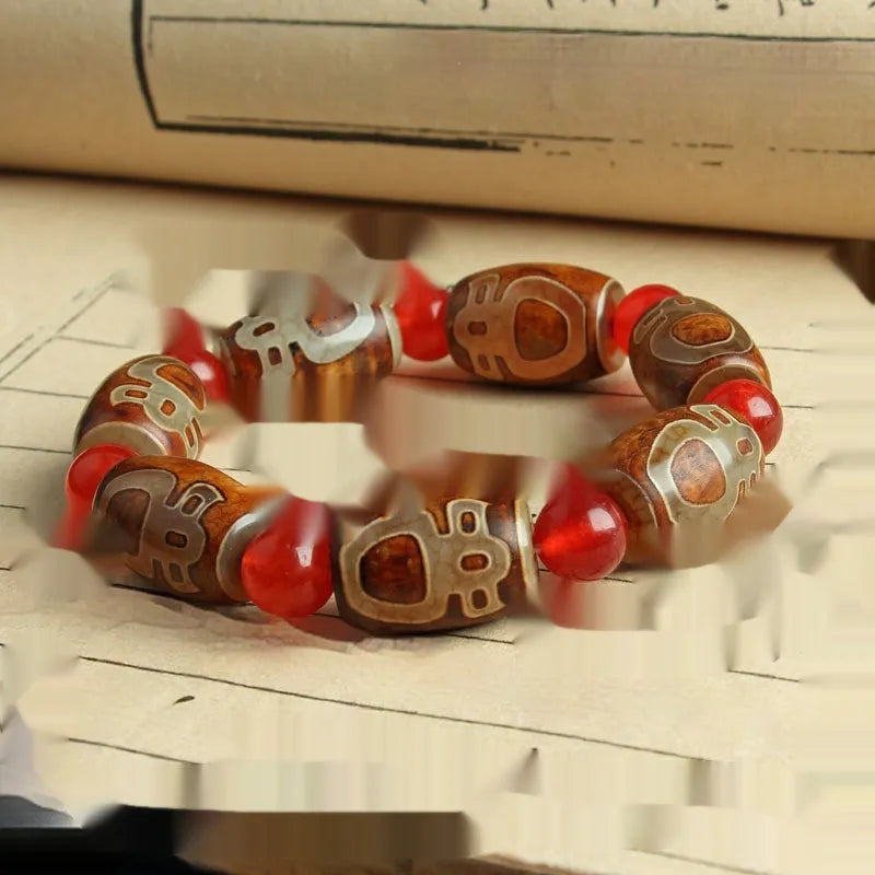 Distressed agate Tibetan bead bracelet with three-eye motifs and polished finish.
