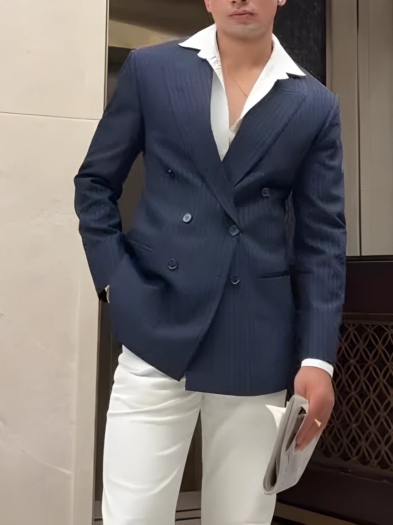 Men's striped double-breasted polyester blazer on a hanger, showing regular fit and length.