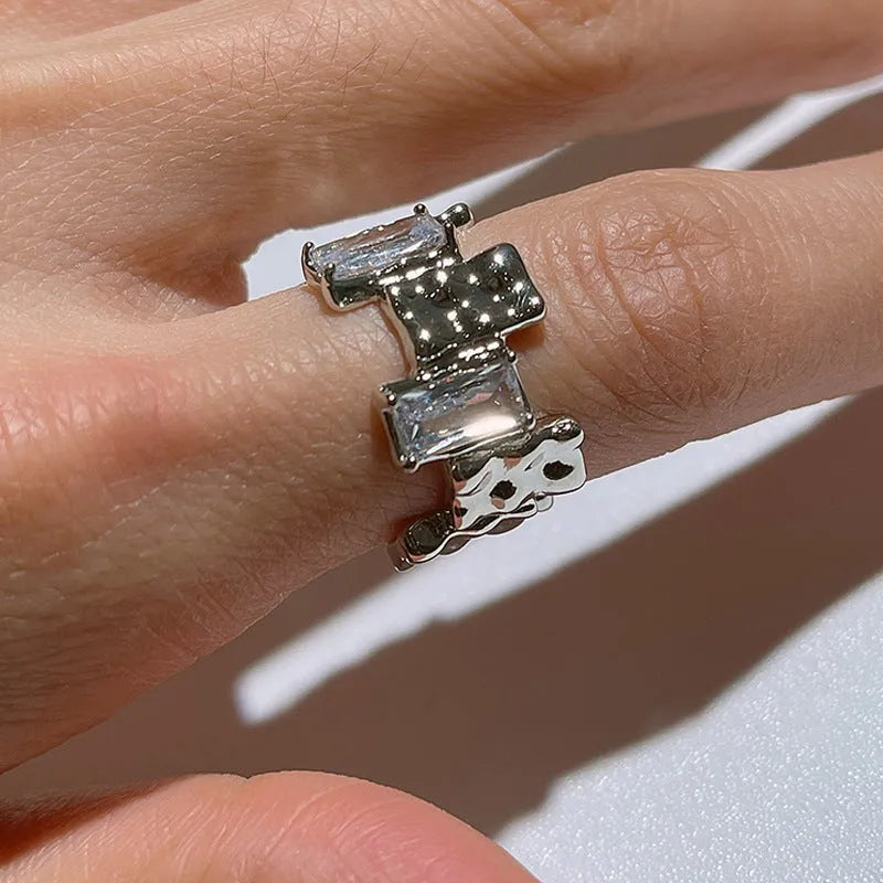 Open geometric zircon ring with three-dimensional decoration in silver colour