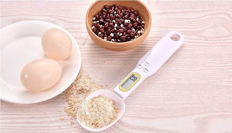 Black digital measuring spoon scale showing weight on display, with spoon bowl for holding materials.