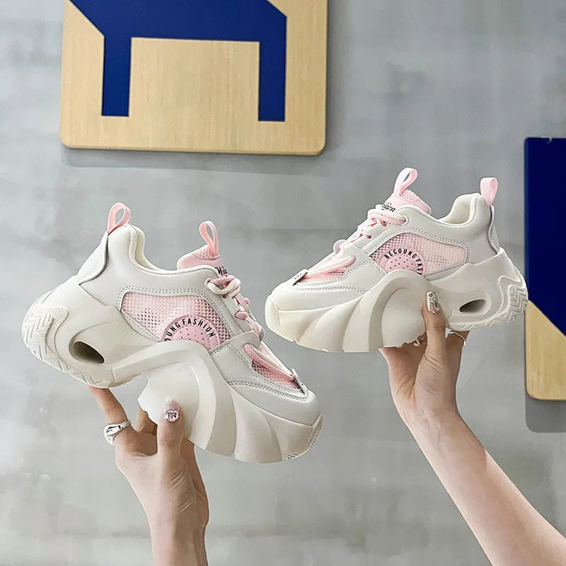Women's pink casual sneakers with cross shoulder straps and a thick sole.