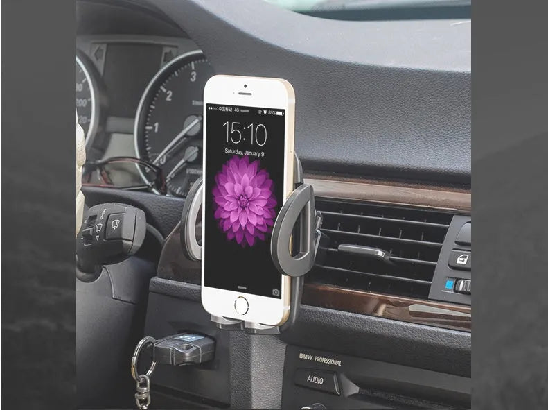 Black plastic car air vent mobile phone holder mounted on a car vent, holding a smartphone.