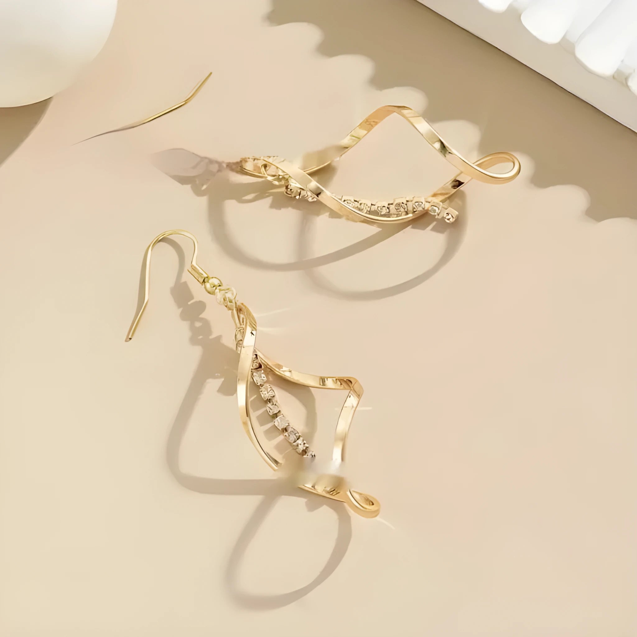Women's gold geometric spiral earrings with ellipse diamond elements on alloy construction