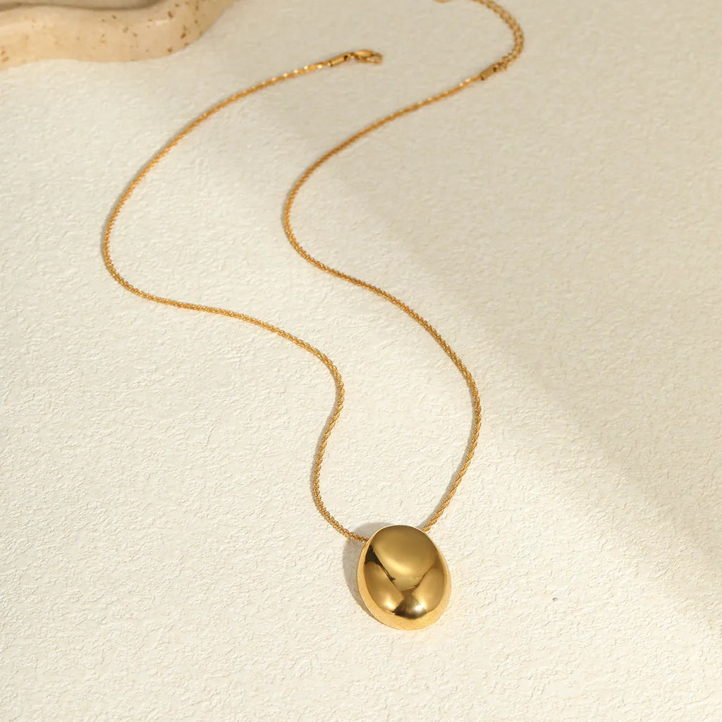 Gold geometric pendant necklace with adjustable chain on jewellery display