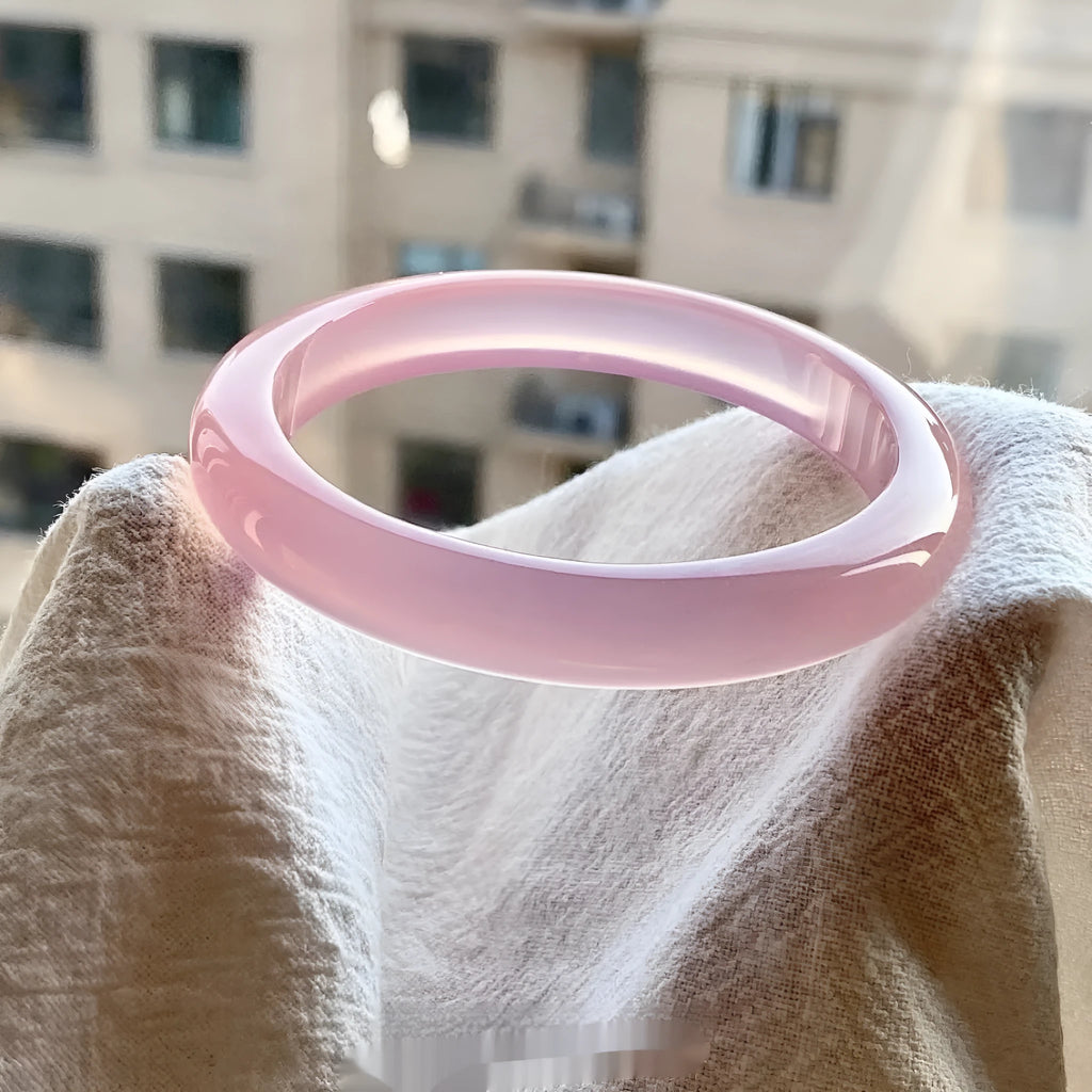 Natural agate wide tire bracelet shown in a pink agate colour variant on a wrist.