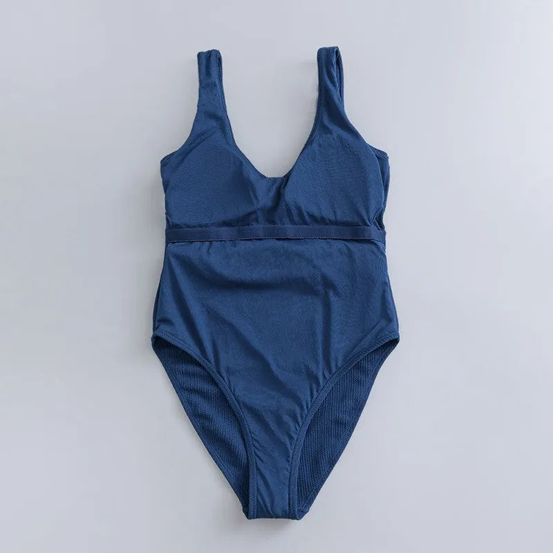 Navy blue women's one-piece triangle swimsuit with chest pads on a mannequin.