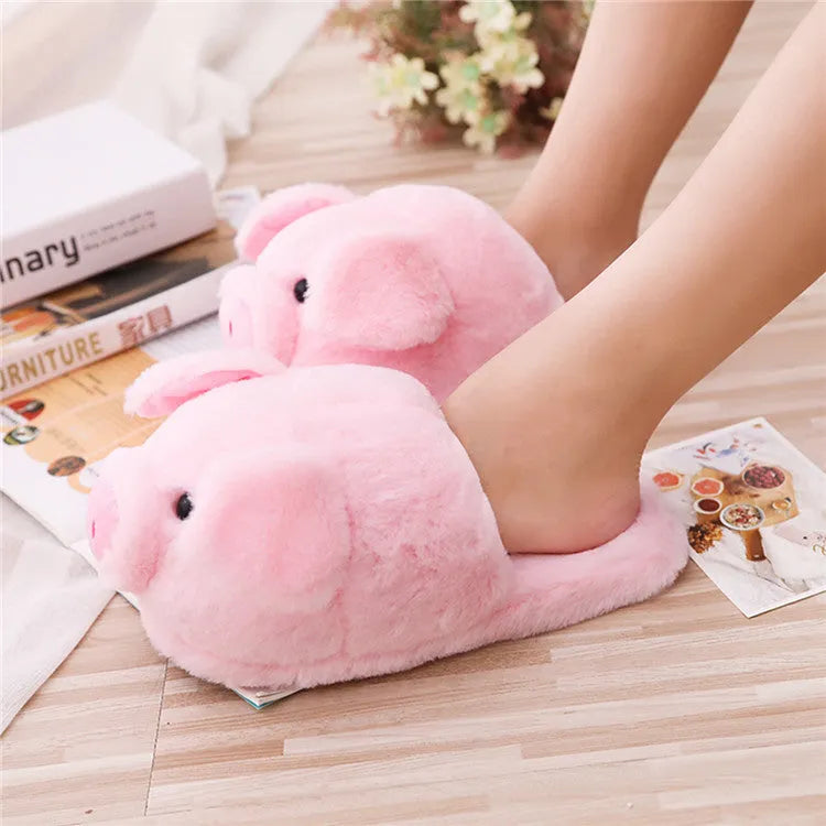 Pink plush floor slippers with a cute pig design on the upper, shown from a side view.