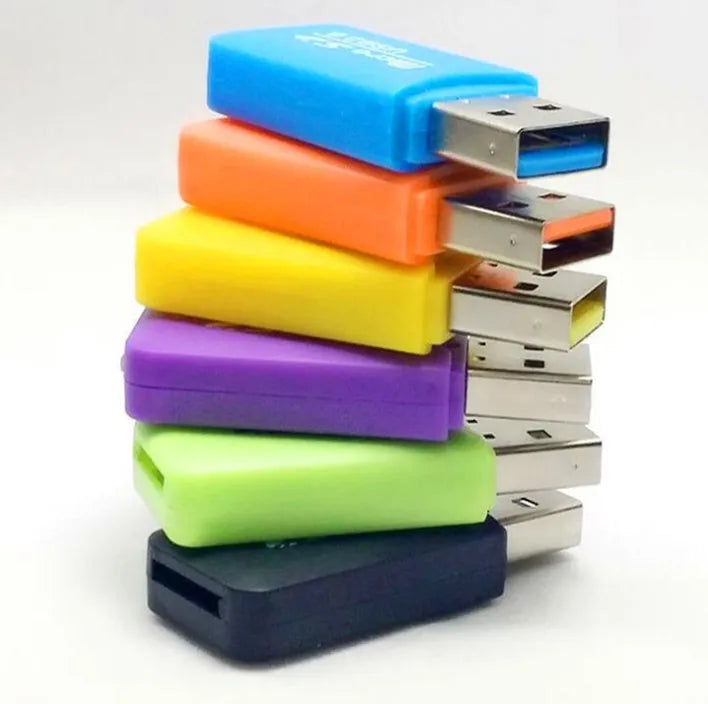 Mini USB card reader with a 16GB MicroSD card and SD card adapter on a table.