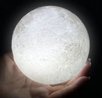 3D printed white moon lamp with detailed craters on a wooden stand, showing touch ring at base.