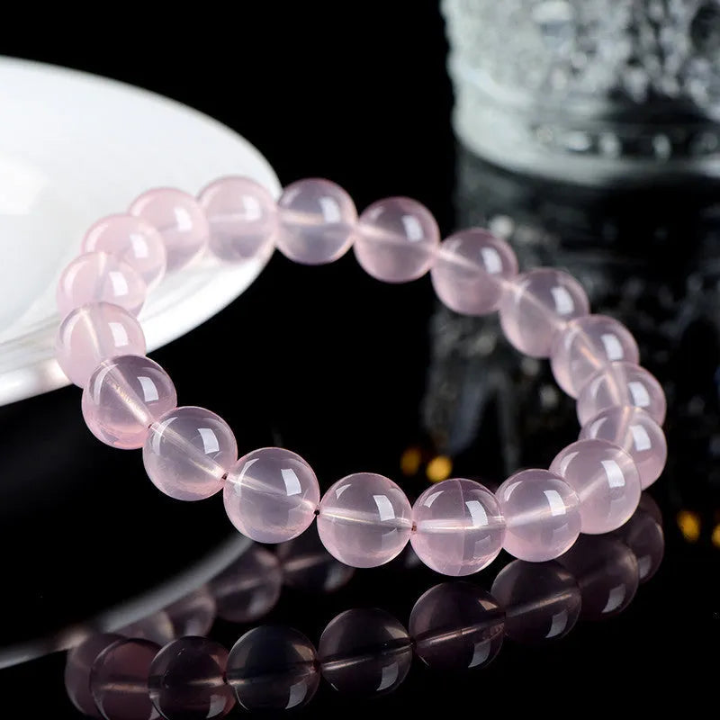 Natural starlight crystal round beads bracelet for women in pink, showing polished beads on a wrist.