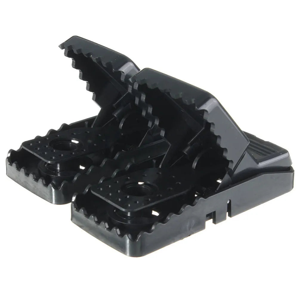 Six black plastic snap mousetraps laid out, each measuring 11 cm long.