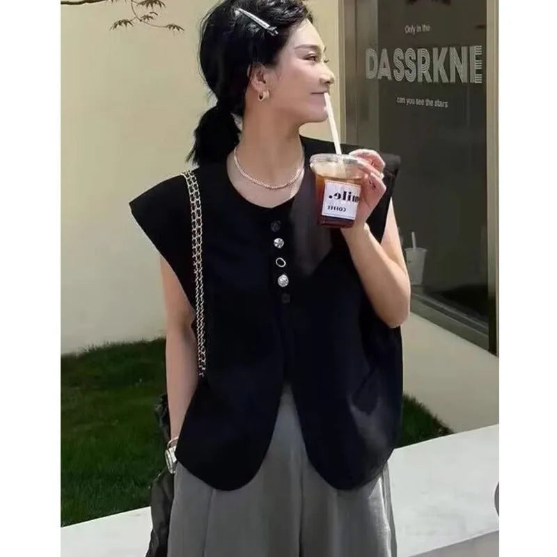 Women's loose fit sleeveless vest in black with a pocket, shown on a hanger.