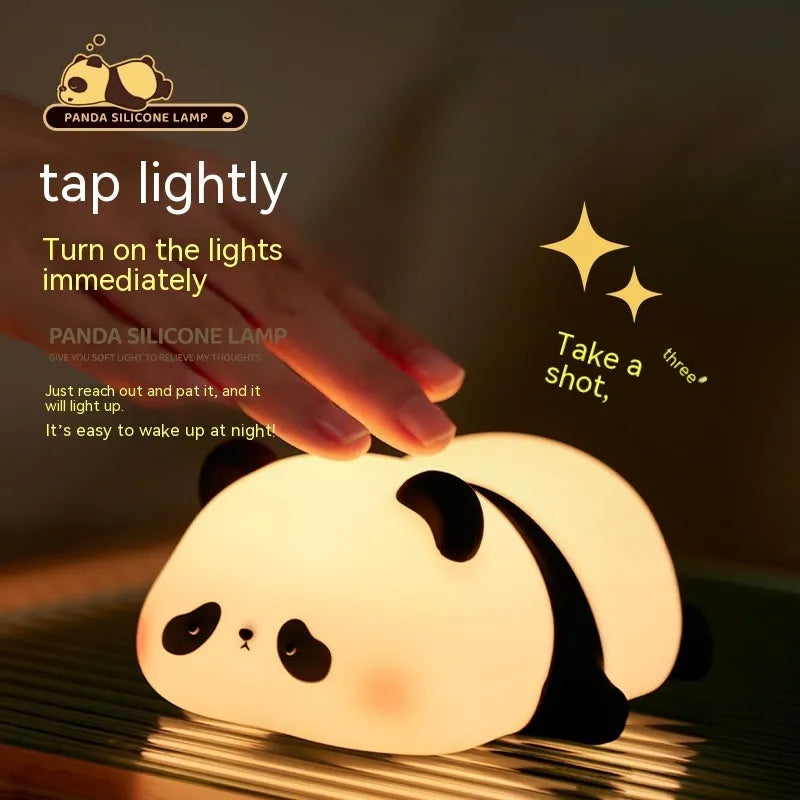 Cute cartoon panda-shaped silicone night light for children on a bedside table.