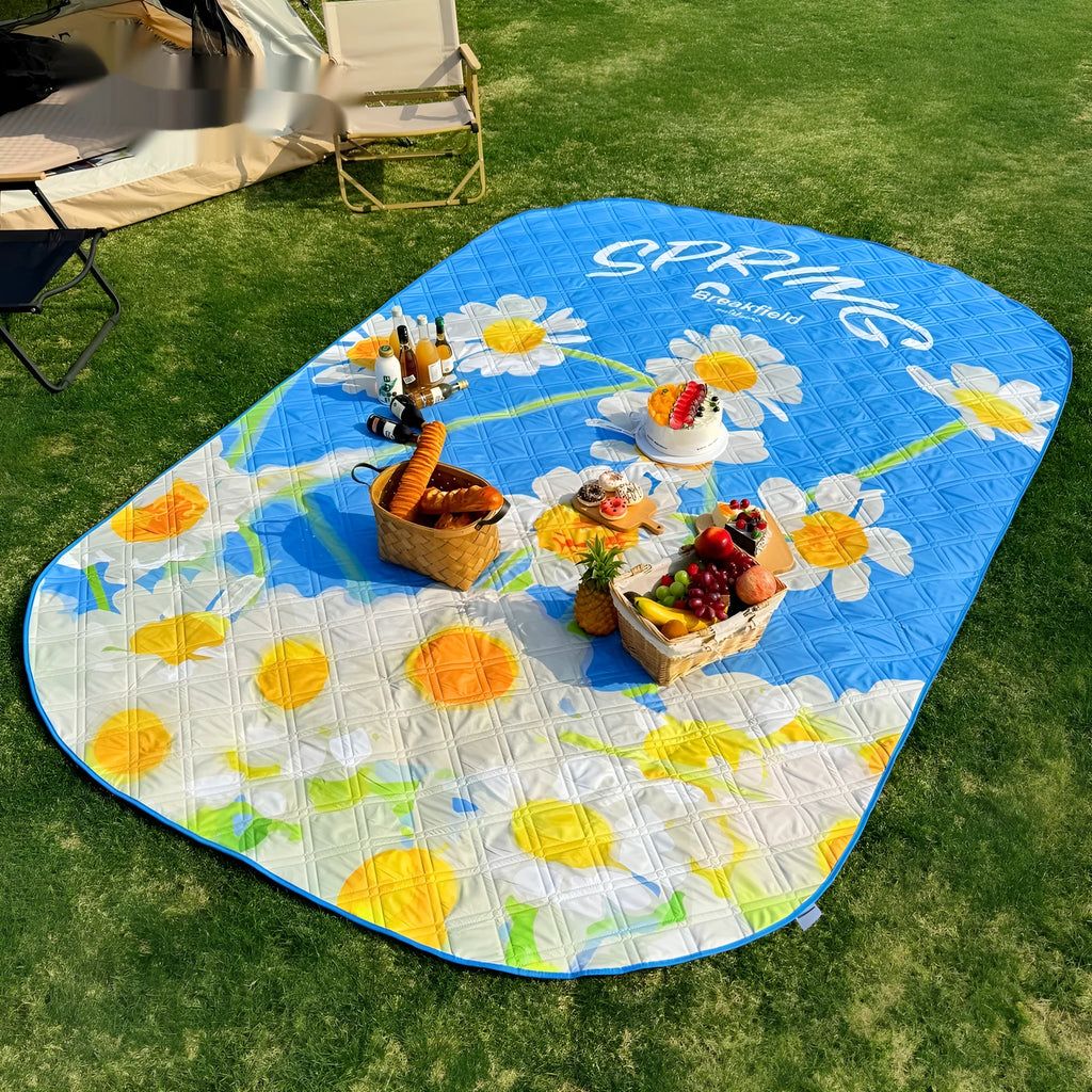 Large blue waterproof picnic mat unfolded on grass, showing texture and size for multiple people.