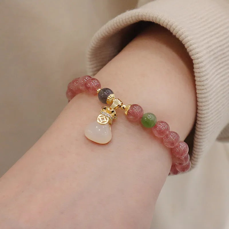 Women's geometric strawberry quartz bracelet with Chinese purse charm and safety buckle clasp.